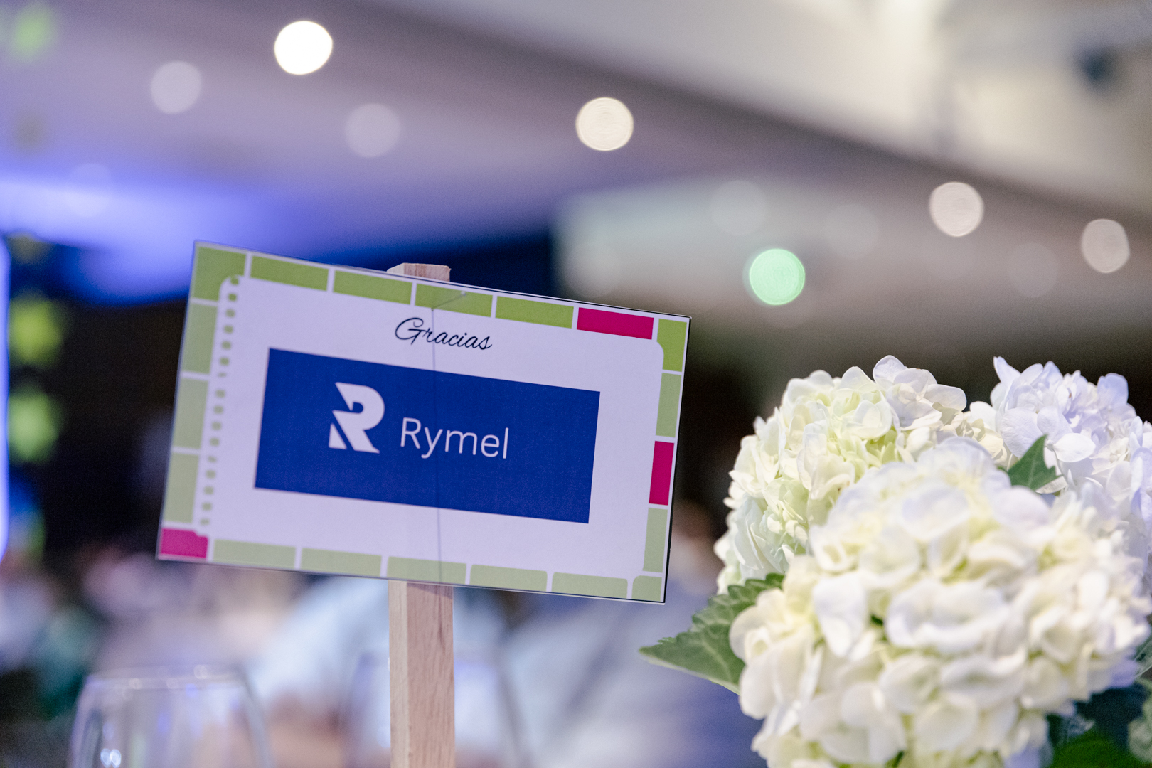 Centro de mesa con tarjeta de agradecimiento a Rymel SAS por su participación en el evento Cena Concierto Fundación Acarpin 2024